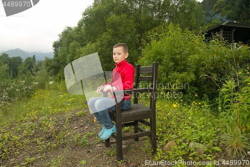 Image of Boy Sitting on Chair in the Forest