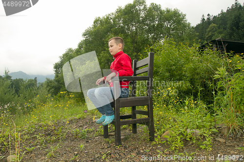 Image of Boy Sitting on Chair in the Forest