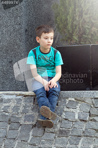 Image of Boy Sitting on the ground Outdoors