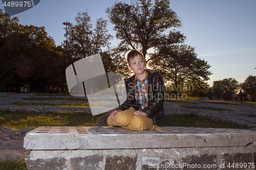 Image of Boy Sitting on the ground Outdoors