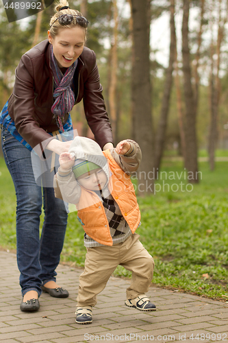 Image of Baby Learning to Walk in Park