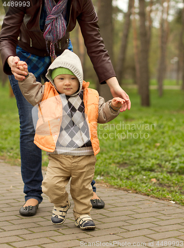 Image of Baby Learning to Walk in Park