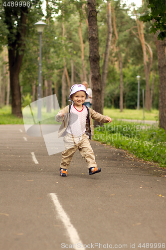 Image of Baby Learning to Walk in Park