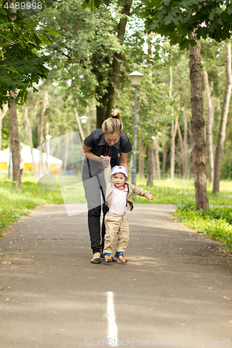 Image of Baby Learning to Walk in Park