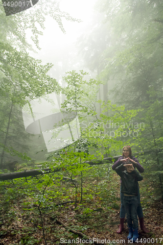 Image of Mother and son in the mystic green foggy forest