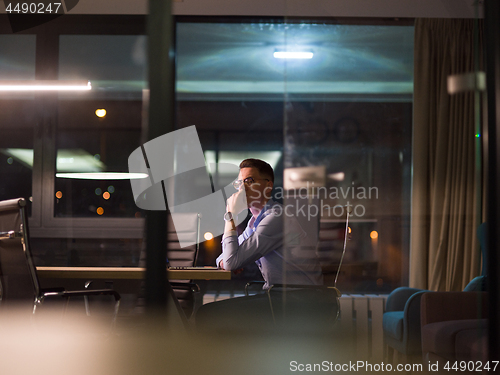 Image of man working on laptop in dark office