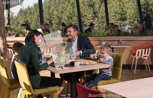 Image of Young parents enjoying lunch time with their children