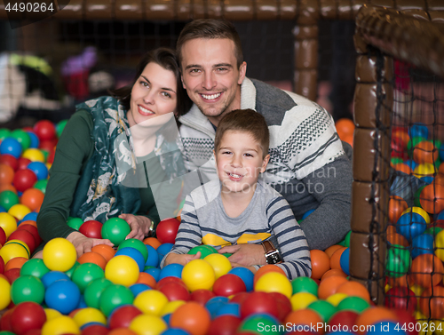 Image of young parents with kids in a children\'s playroom