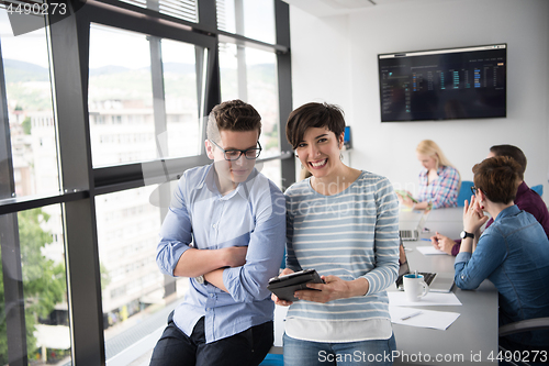 Image of Two Business People Working With Tablet in office