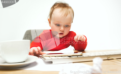 Image of Happy child baby girl toddler sitting with keyboard of computer isolated on a white background