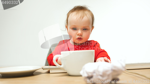 Image of Happy child baby girl toddler sitting with keyboard of computer isolated on a white background