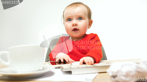 Image of Happy child baby girl toddler sitting with keyboard of computer isolated on a white background