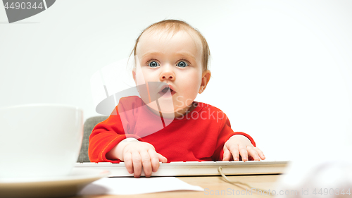 Image of Happy child baby girl toddler sitting with keyboard of computer isolated on a white background