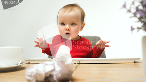 Image of Happy child baby girl toddler sitting with keyboard of computer isolated on a white background