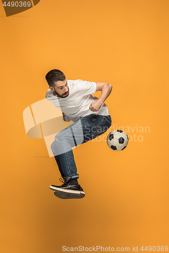 Image of The young man as soccer football player kicking the ball at studio