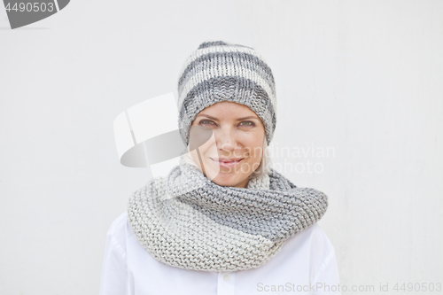 Image of Young woman in warm grey knitted hat and snood