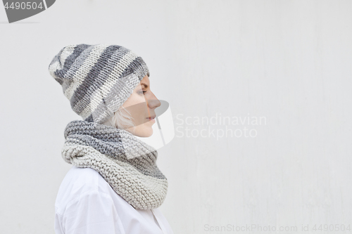 Image of Young woman in warm grey knitted hat and snood