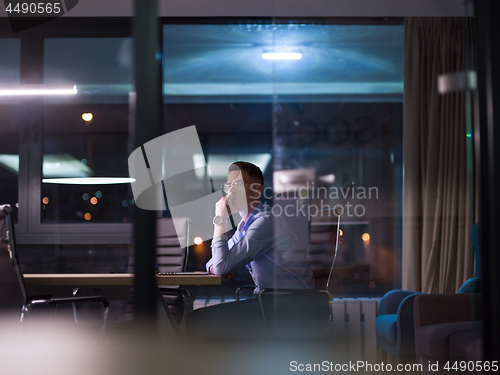 Image of man working on laptop in dark office