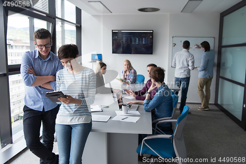 Image of Two Business People Working With Tablet in office