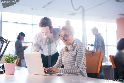 Image of Two Business People Working With laptop in office