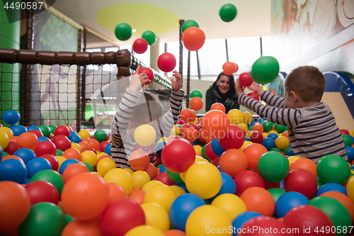 Image of Young mom with her kids in a children\'s playroom