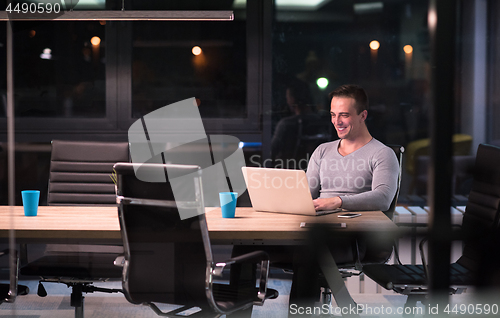 Image of man working on laptop in dark office