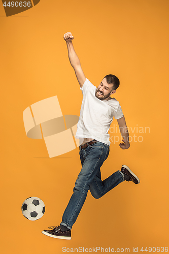 Image of The young man as soccer football player kicking the ball at studio