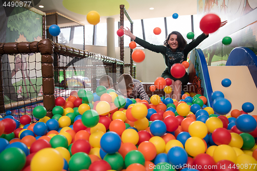 Image of Young mom with her kids in a children\'s playroom