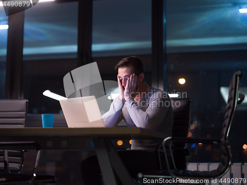 Image of man working on laptop in dark office