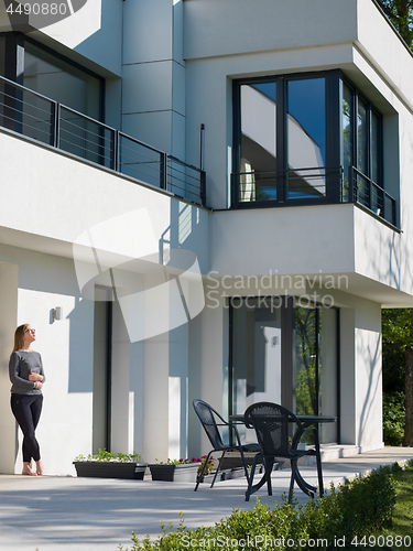 Image of women using tablet computer in front of luxury home villa