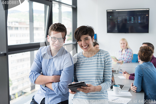 Image of Two Business People Working With Tablet in office