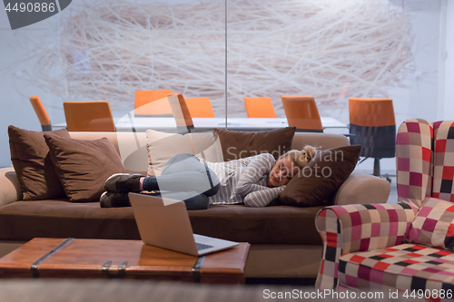 Image of woman sleeping on a sofa  in a creative office