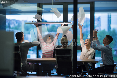 Image of multiethnic Group of young business people throwing documents