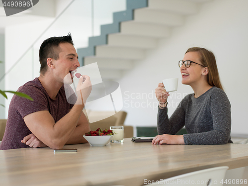Image of couple enjoying morning coffee and strawberries