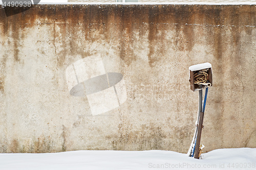 Image of abandoned grunge house with electrical equipment near the wall in winter.