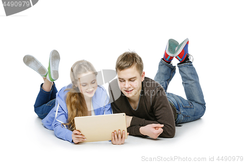 Image of Teen boy and girl sitting with tablets