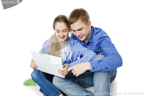 Image of Teen boy and girl sitting with tablets