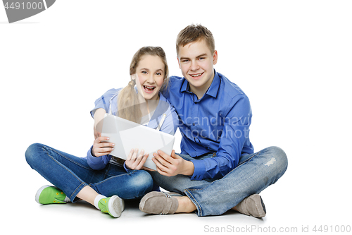 Image of Teen boy and girl sitting with tablets