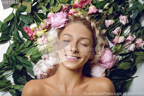 Image of Beautiful girl lying in flowers