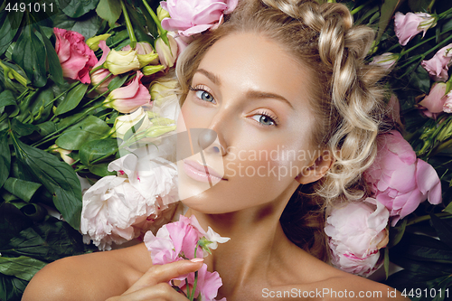 Image of Beautiful girl lying in flowers