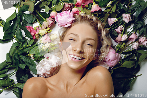 Image of Beautiful girl lying in flowers