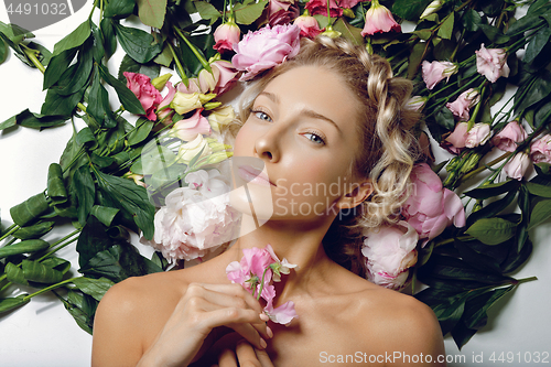 Image of Beautiful girl lying in flowers