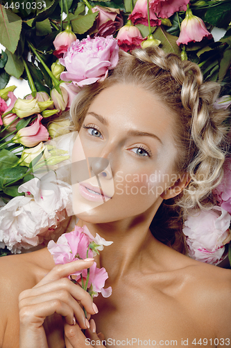 Image of Beautiful girl lying in flowers
