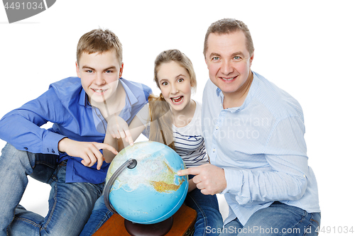 Image of father with children looking at earth globe