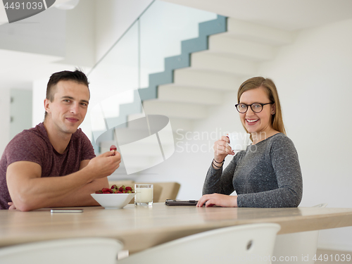 Image of couple enjoying morning coffee and strawberries