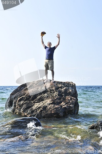 Image of Man stranded on a rock in ocean