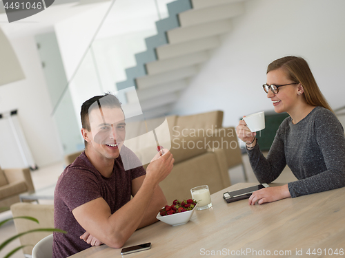 Image of couple enjoying morning coffee and strawberries