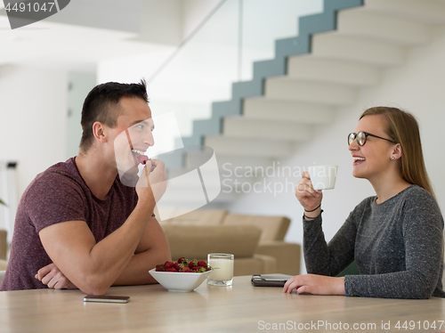 Image of couple enjoying morning coffee and strawberries