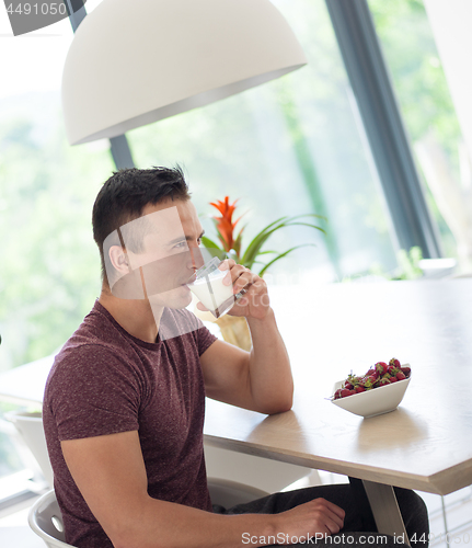 Image of couple enjoying morning coffee and strawberries