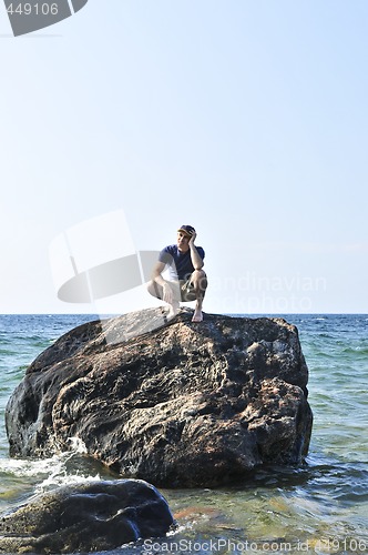 Image of Man stranded on a rock in ocean